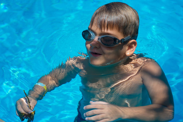 Un niño, un niño nada en la piscina en un cálido día de verano. Childhoo.
 - Foto, Imagen