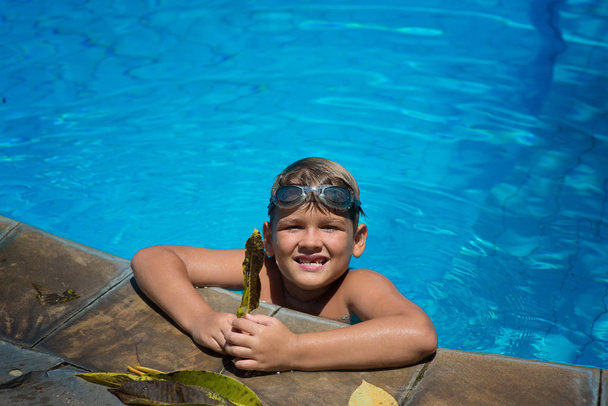 Ein Junge, ein Kind schwimmt an einem warmen Sommertag im Pool. Kinderhoo - Foto, Bild
