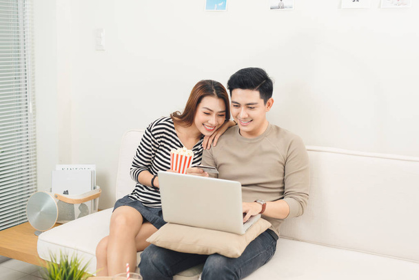 Giovane asiatico coppia pagamento online utilizzando laptop acquisto film tick
 - Foto, immagini