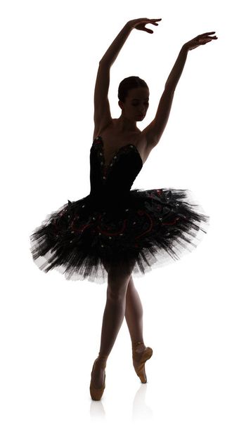 Ballerina-Silhouette macht Ballettposition Arabeske vor weißem Hintergrund - Foto, Bild
