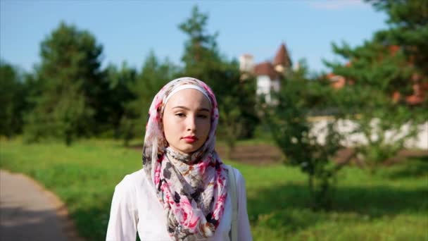 Nuori arabinainen kävelee puistossa yllään hijab moderni kaupunki
 - Materiaali, video