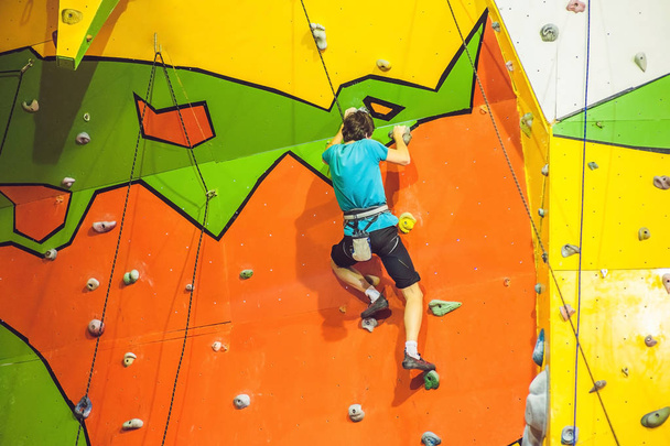 Man climber on artificial climbing wall  - 写真・画像