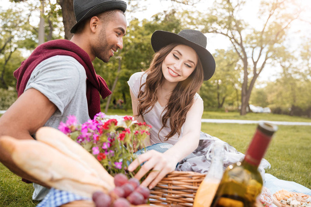 Happy beautiful young couple having fun on picnic in park - 写真・画像