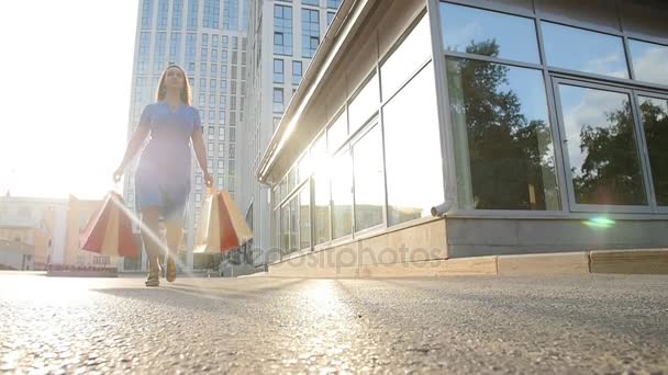 Genç kadın alışveriş torbaları ile cadde boyunca yürüyor - Video, Çekim