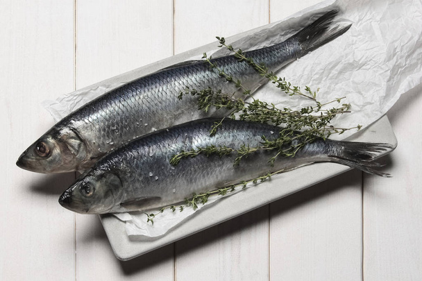 salted herring on a white wooden background - Φωτογραφία, εικόνα