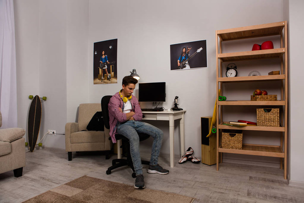 Annoyed teenage boy sitting in his room. - Foto, Bild