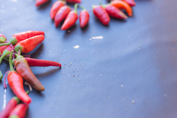 Red hot chili papričky venku. Červené a zelené papriky na pozadí tmavě deska - Fotografie, Obrázek
