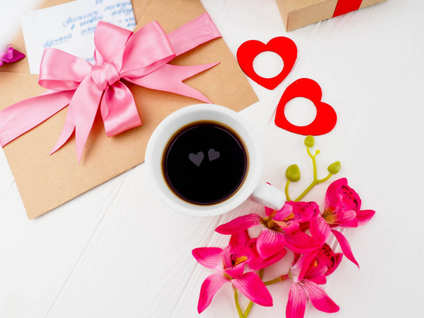 Kaffeetasse, enge rosa Geschenke, Buchstaben und zwei Herzen in der Tasse, das Konzept der Romantik, Liebe - Foto, Bild