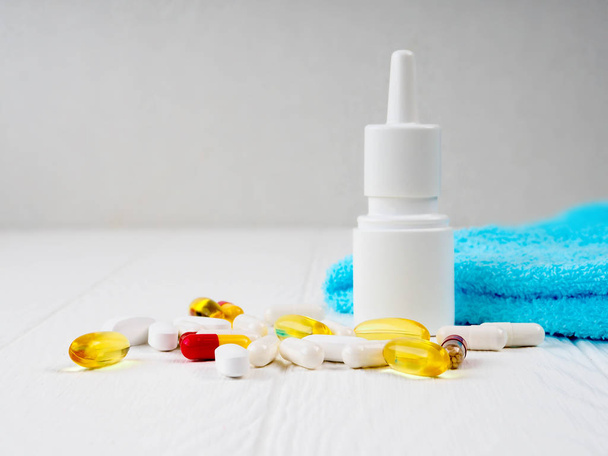 gezondheidszorg, geneeskunde en medicijnen concept - pillen, neusspray, antipyretische siroop en glas op houten tafel - Foto, afbeelding