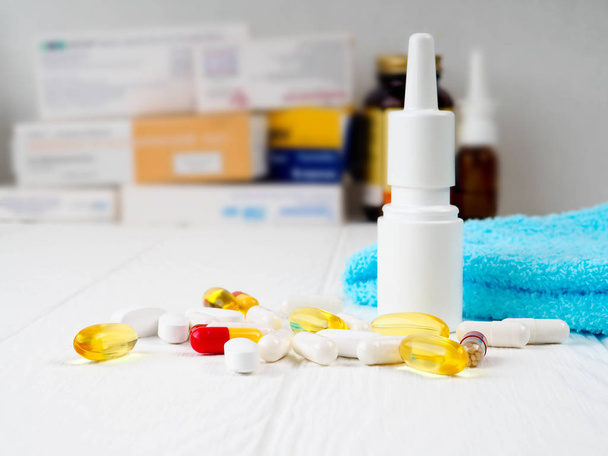 salute, medicina e farmaci concetto pillole, spray nasale, sciroppo antipiretico e vetro sul tavolo di legno
 - Foto, immagini