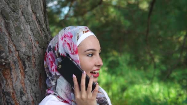 Happy Muslim woman talking on mobile outdoor - Záběry, video