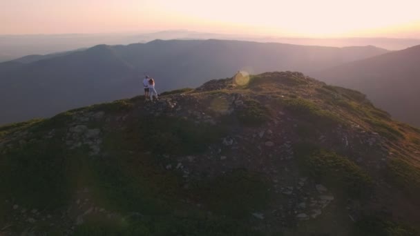 Aerial shot of couple standing on top of mountain - Footage, Video