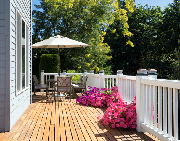 Home cedar deck during bright summer day with blooming garden of - Photo, Image