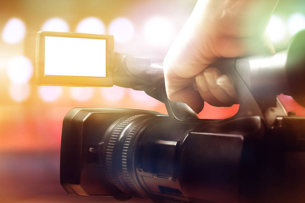 hand of cameraman holding professional video camcorder in studio - Photo, Image
