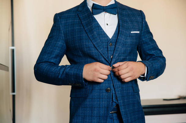 Close-up businessman groom wearing his jacket. Concept of men stylish elegance clothes - Фото, изображение
