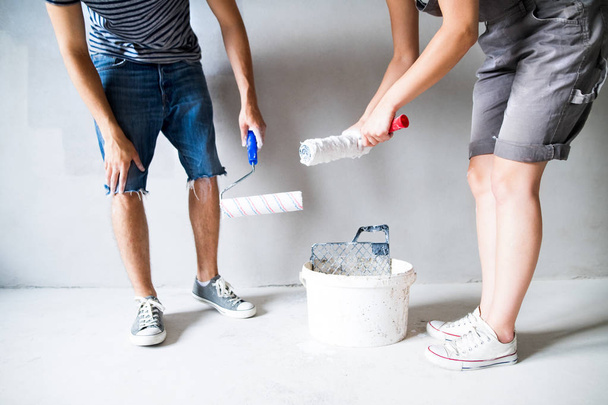 Unrecognizable young couple painting walls in their new house. - Foto, Imagem