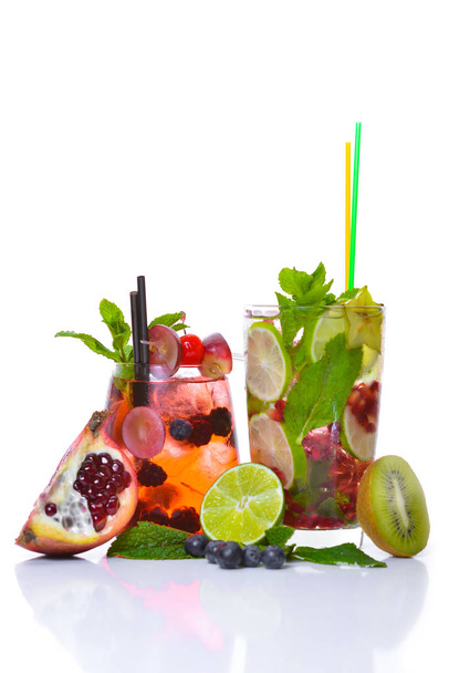 A fresh cocktail of tropical fruit and juice with ice. Fresh fruit lime, lemon, mint, kiwi. Top view. On a white background. - Foto, Bild