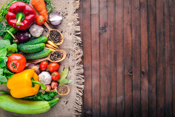 有機食品のフレームです。新鮮な生の野菜やスパイス。木製黒板. - 写真・画像