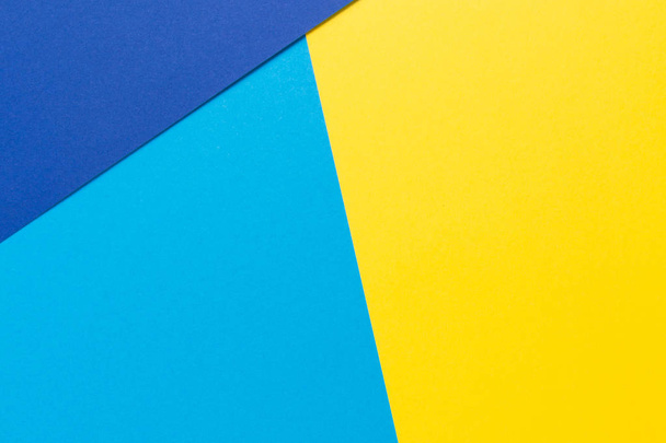 Color papers geometry flat composition background with yellow and blue tones - Foto, afbeelding