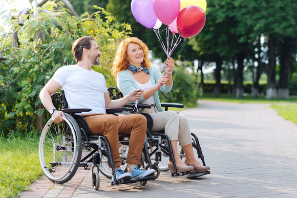Joyful disabled couple holding balloons - Fotografie, Obrázek