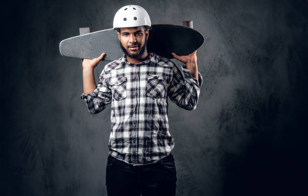 Schwarzer Skater hält langes Brett - Foto, Bild