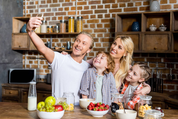 família tomando selfie durante o café da manhã
 - Foto, Imagem