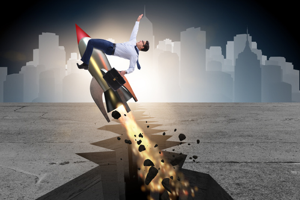 Businessman flying on rocket from rock gap - Photo, Image