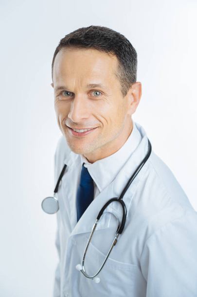 Cheerful mature physician looking into camera with smile on face - Fotoğraf, Görsel
