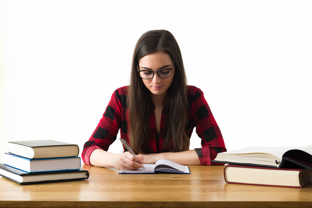 Attractive caucasian girl studying for her exams at home, education concept on white background - Foto, imagen
