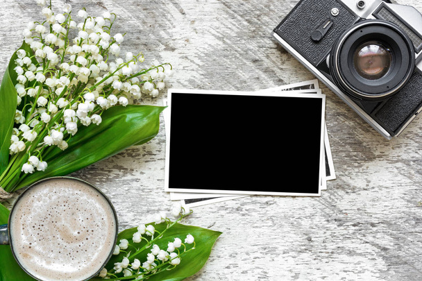 cámara retro vintage con foto en blanco y taza de café con lirio de las flores del valle
 - Foto, imagen