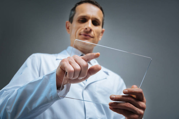 Selective focus on transparent gadget held by mature man - Foto, afbeelding