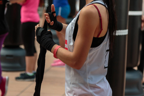 Meisje rollende gele Hand Wraps: Fitness- en Workout Boksen - Foto, afbeelding