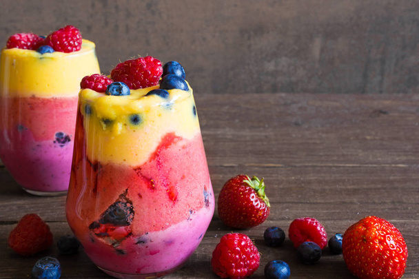 delicious homemade layered fruit and berry smoothie dessert in glasses - Foto, Imagem