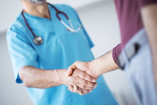 Doctor shakes hands with a patient - Foto, afbeelding