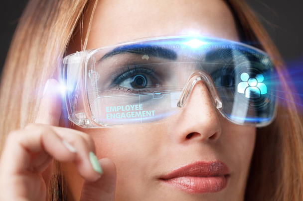 Giovane donna d'affari che lavora in occhiali virtuali, selezionare l'icona coinvolgimento dei dipendenti sul display virtuale
 - Foto, immagini