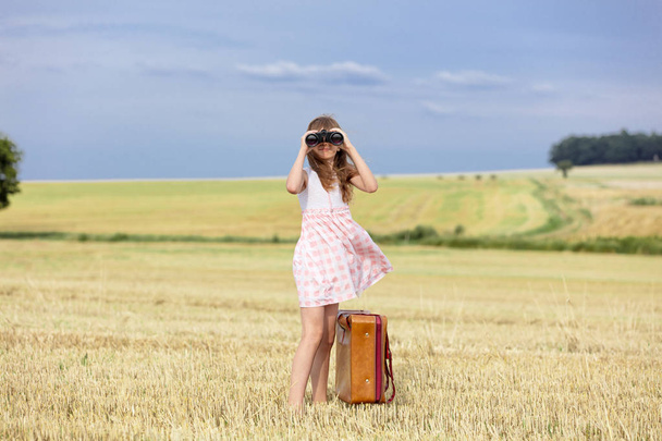 Girl with travel suitcase and binoculars - Photo, image