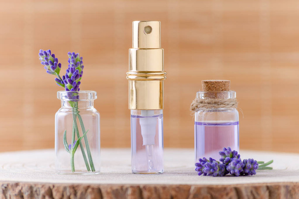 lavender water in glass bottles and fresh lavender flowers for relax on brown background - Photo, Image