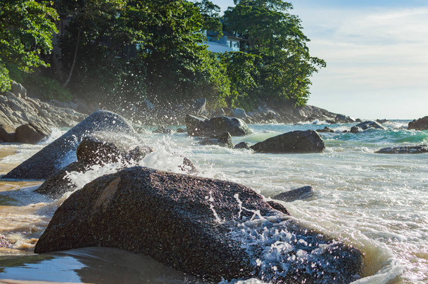 石に対して海の波しぶき - 写真・画像