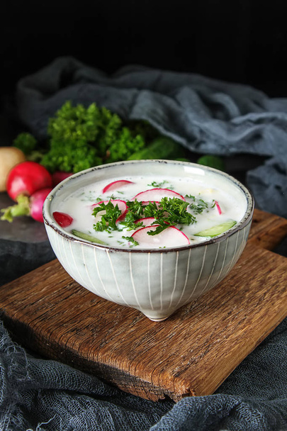 Summer cold soup - okroshka in a ceramic bowl. Ingredients of po - Zdjęcie, obraz