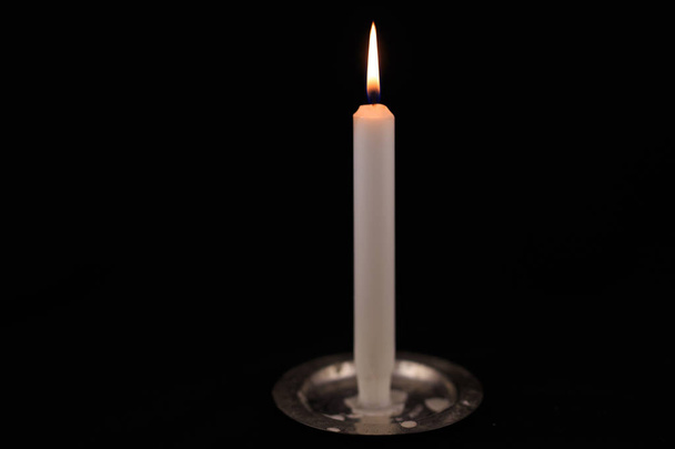 біла свічка, що горить на чорному ізольованому фоні
.  - Фото, зображення