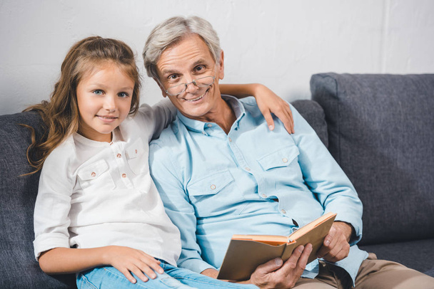 grootvader en kleindochter leesboek - Foto, afbeelding