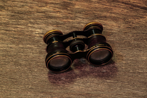 Old binoculars on a wooden background - Photo, Image