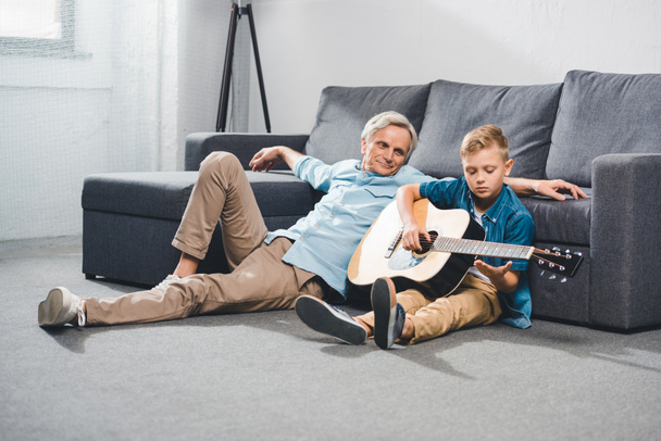 grand-père et petit-fils jouant à la guitare
 - Photo, image