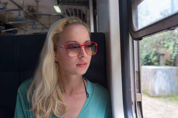 Sarışın, beyaz kadın trene biniyor, camdan içeri bakıyor.. - Fotoğraf, Görsel
