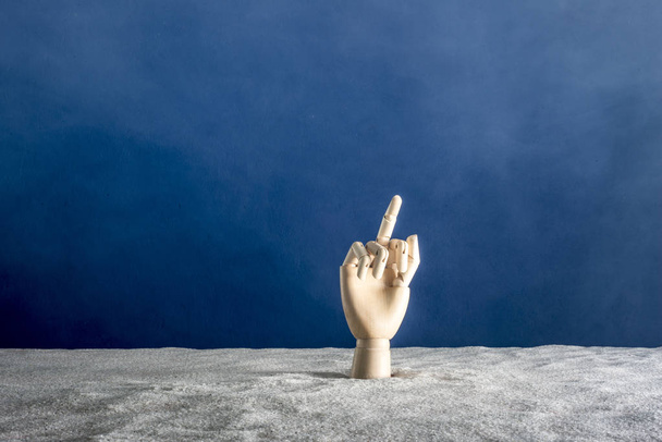 A hand of wood gesticulates on a blue ony - Zdjęcie, obraz