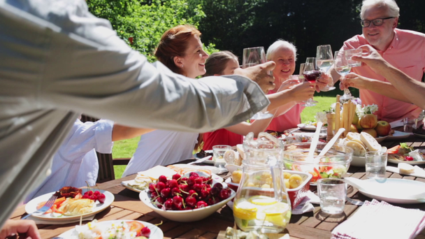 famiglia felice che cena o festa estiva in giardino - Filmati, video