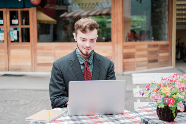 À la recherche de direction et d'inspiration, Portrait de jeune homme d'affaires heureux assis avec ordinateur portable  - Photo, image
