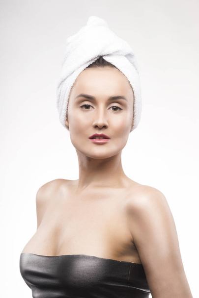 Portrait of the beautiful mature woman with a white towel on the - Foto, Imagen