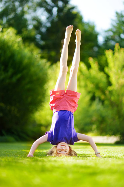 girl playing head over heels on grass - Foto, immagini