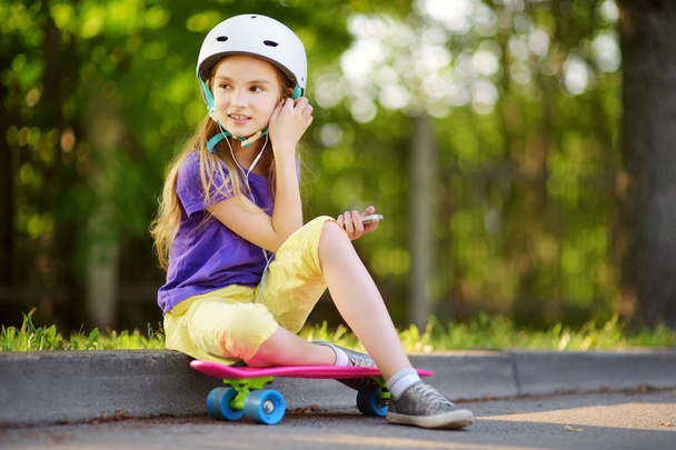 little girl learning to skateboard in park - Фото, зображення